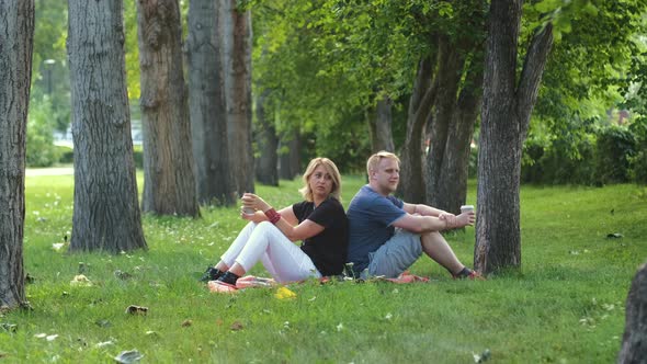 Mother and Adult Son Talk While Resting in Park