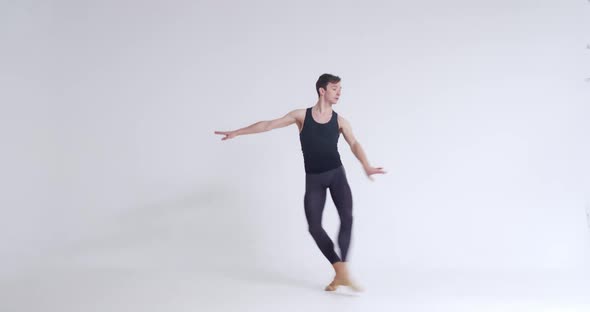 Elegant Man Ballet Dancer Performs Acrobatic Elements and Pirouette Ballet Dance on a White
