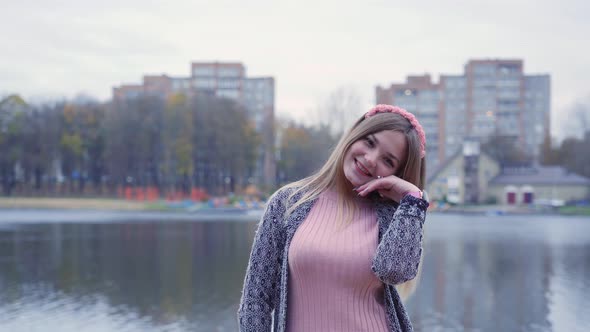 Girl Posing in the Autumn Evening Against the Backdrop of a City Lake