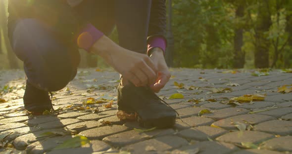 Young Fitness Woman Tying Sneakers Running Shoe Laces in Park