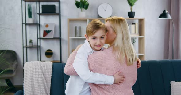 Boy which Hugging with His Pretty Loving 35-Aged Mother in Beautifully Decorated Sitting Room