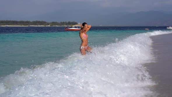 Idyllic View of Sexy Woman in Swimsuit Biking Going Out From Wavy Clean Ocean Paradise Vacation Joy