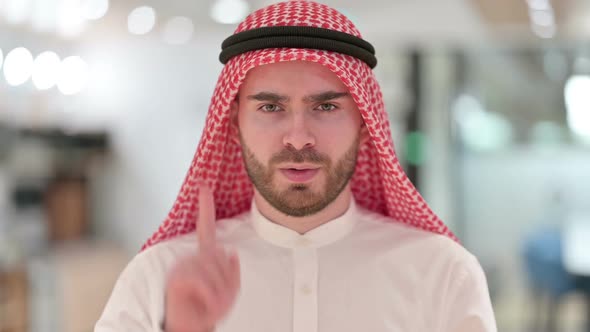 Portrait of Serious Arab Businessman Saying No By Finger Sign