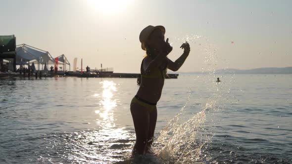 Silhouette of Young Girl Play on Ocean at Sunset. Summer Vacation, Positive Mood.