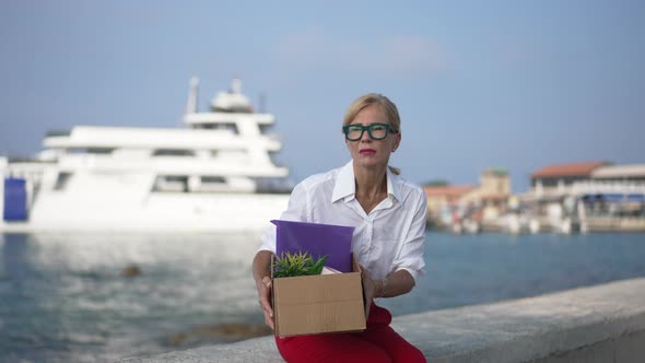 Desperate Hopeless Caucasian Businesswoman Sitting Down on Embankment Holding Head in Hands Sighing