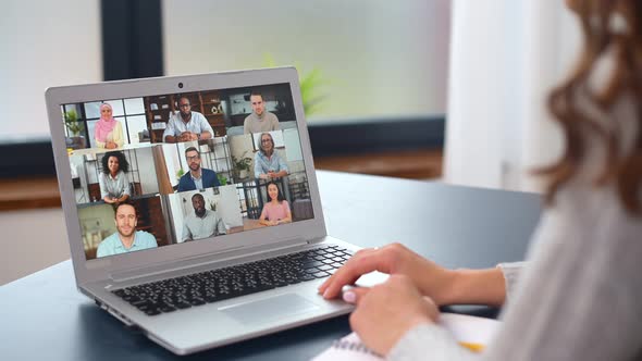 Young Woman Using a Laptop for Video Connection with Diverse Group of People