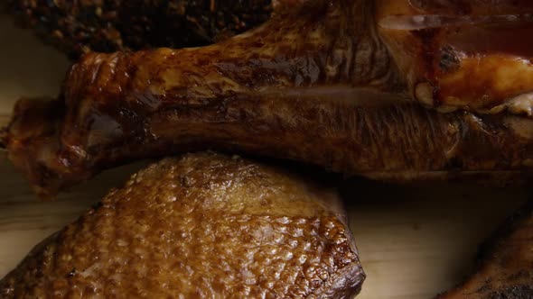 Rotating shot of a variety of delicious, premium smoked meats on a wooden cutting board