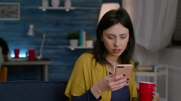 Beautiful Woman Holding Phone in Hand Reading Message on Internet