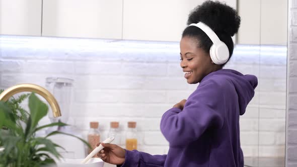 African American Black Handsome Woman Cooking Dancing with Headphones Enjoy Life Listening Favourite