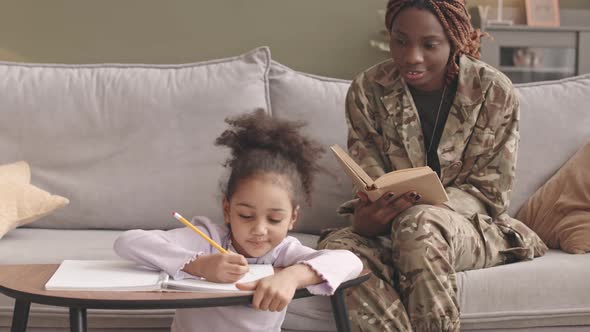 Military Woman Spending Leisure Time with Daughter at Home alt