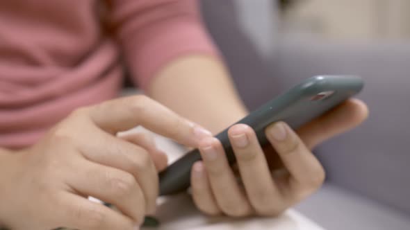 Close up focus on woman hands using a smartphone to social media. Technological addiction concept.