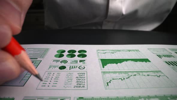 Accountant Analyzing Business Marketing Data on Paper Dashboard at Office Table