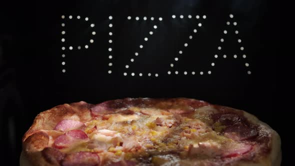 Delicious Fresh Italian Pizza On A Black Background With  The  Effect Of Light Inscription Pizza