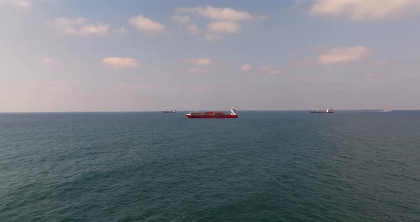 Container ship loaded with Shipping containers holding position at sea.