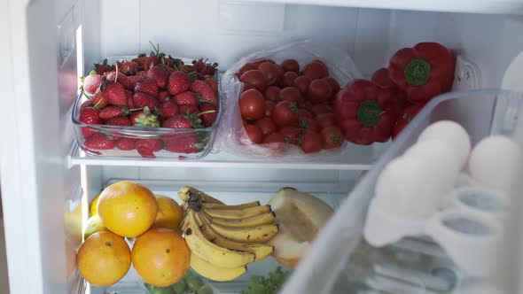 Opening Refrigerator Door Full of Tasty Fresh Vegetables Fruits Strawberry