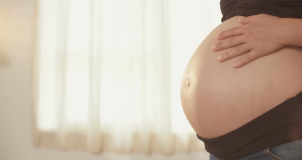 Pregnant woman holding her belly