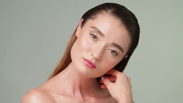 Beautiful Young Woman with Clean Fresh Skin Standing Over Light Grey Background