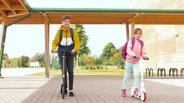 Children Riding Scooters at School Yard