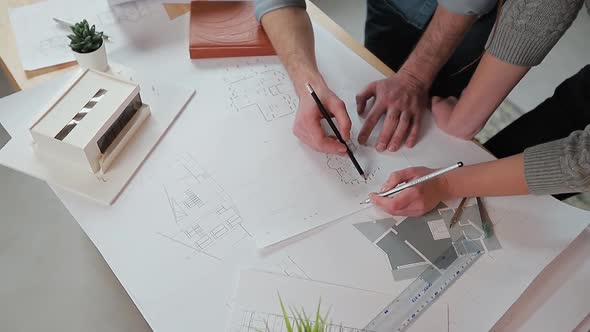 Close Up Hands of Two Workers Discussing Building Drawings in Office, Closeup Shooting of Arms