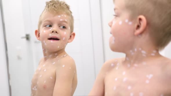 Little Boy Examines Himself in the Mirror
