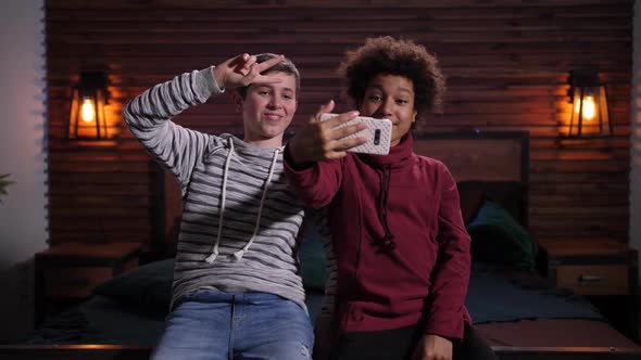 Smiling Mixed Race Teens Posing for Selfie Indoors