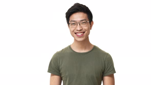Portrait of Smiling Asian Man Wearing Eyeglasses and Basic Tshirt Nodding in Acceptance Meaning Yes