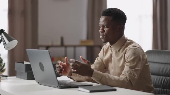 Young Black Businessman is Communicating By Video Call on Laptop with Colleagues or Employees Online