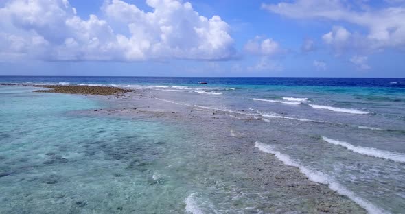 Wide aerial travel shot of a white paradise beach and aqua blue water background in high resolution 