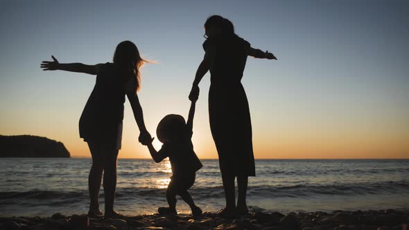 Happy Family Mother with Two Children on Vacation at the Beach. Silhouette Mother with Two Children