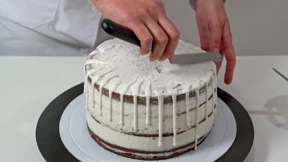 Close Up of a Chef Polishing the Top of a Cake By Spreading the White Chocolate