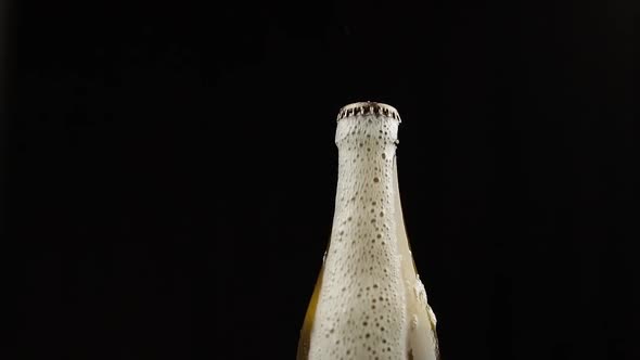 Man Shakes a Bottle of Beer. Beer Begins To Pour Out with Foam Rom Under the Lid