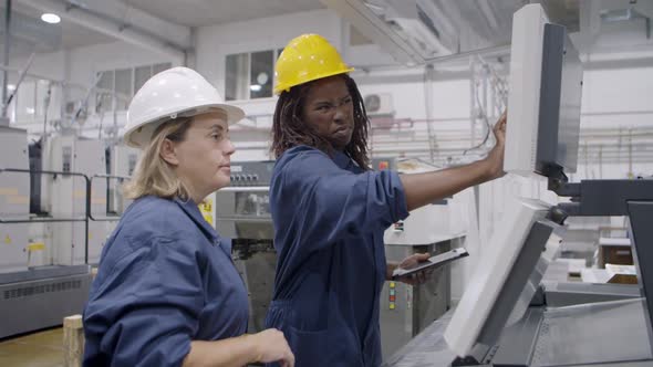 Black Female Factory Mentor Showing Machine