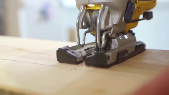 Carpenter Cuts Wood with Electric Jigsaw
