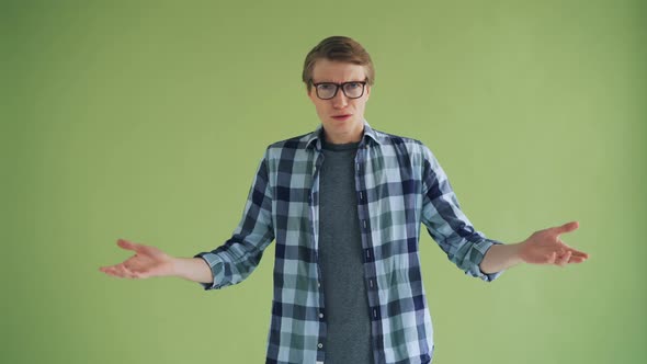 Portrait of Disappointed Man Looking at Camera on Green Background Then Leaving