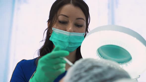 Woman in Mask Does Antiaging Injections To Middle Aged Lady