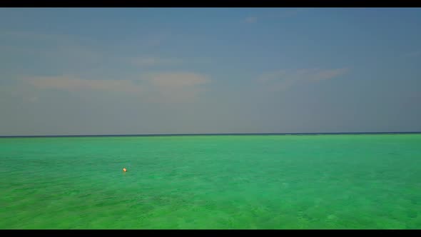 Aerial drone shot seascape of idyllic shore beach trip by aqua blue ocean and bright sand background