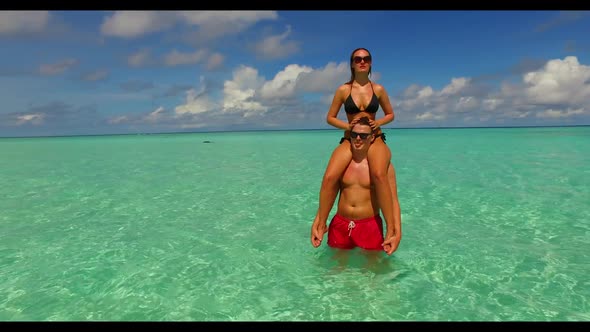 Guy and girl posing on perfect coastline beach vacation by aqua blue lagoon with white sand backgrou