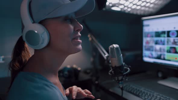Beautiful Woman In A Cap And White Headphones Leads A Live Stream