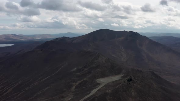 Aerial View of the Mountain Against the Background of Clouds and a Mountain Range