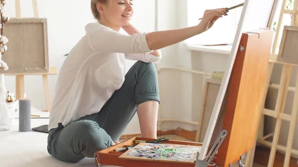 Happy Girl Laughing at Somebody While Painting in the Room