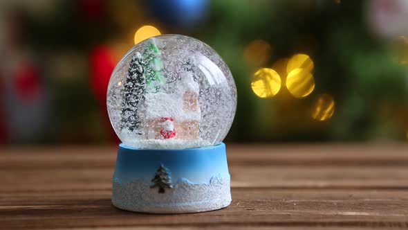 Christmas Snow Globe Snowflake with Snowfall on Xmas Tree Background