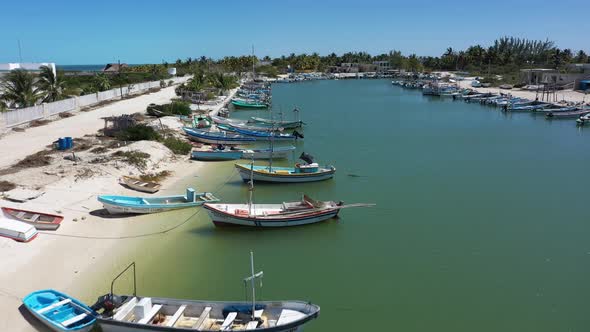 Low aerial fly over small fishing boats in a harbor in Yucatan, Mexico on a sunny day..