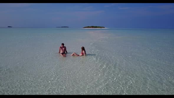 Two lovers happy together on idyllic sea view beach holiday by blue ocean and white sandy background