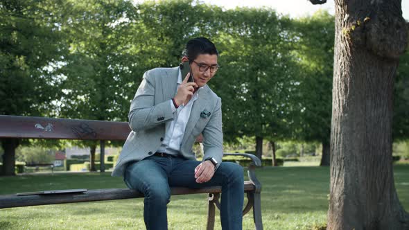 Korean Businessman On Phone Call In Park