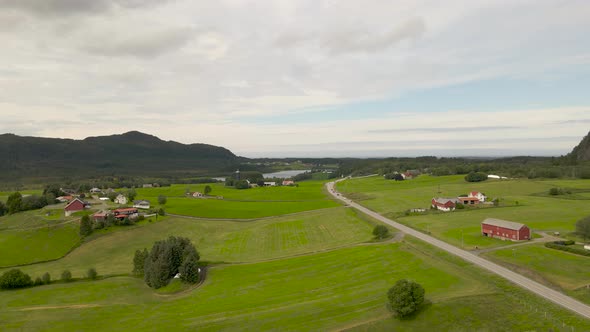 Aerial shot flying over a farm and fields in the rural countryside of Norway