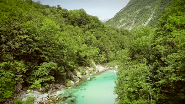 Aerial view of the Soca river surrounded by nature at summer time in Slovenia.