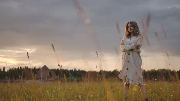 Sensual Woman Strolling in Field with Folded Arms