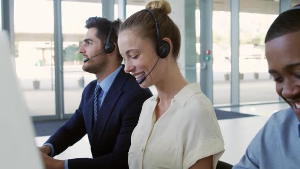 Young business people wearing headsets in a modern office