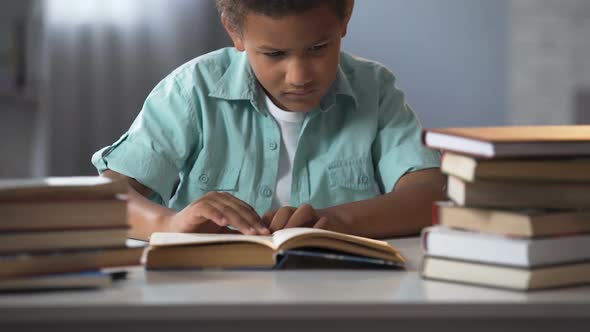 Male Child Tired of Doing Lot of Homework and Falling Asleep While Reading Book