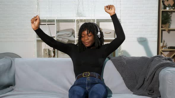 Fashionable Black Lady in Pullover Jeans Listens To Music